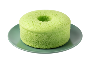A light green, textured sponge cake sits on a muted teal plate against a black backdrop.
