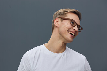 Smiling man with glasses, short gray hair, wearing a plain white t-shirt, looking to the side,...