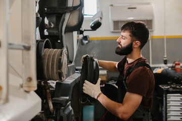 Fototapeta premium Mechanic replacing air filter in a truck engine during maintenance