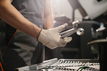 Auto mechanic choosing correct socket wrench for repairing trucks