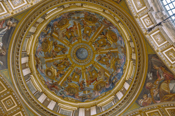 Fototapeta premium Ornate dome featuring golden accents and heavenly figures painted on the interior. Captures history and artistry with its design.