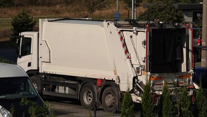 Śmieciarka pod altaną śmietnikową odbierająca śmieci © tomo81