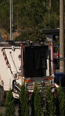 Śmieciarka pod altaną śmietnikową odbierająca śmieci © tomo81