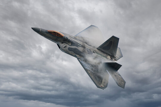 F-22 Raptor slicing through humid air, forming vapor cones during a high-speed maneuver. Great for defense industry visuals, educational content, military aviation editorials, and posters.