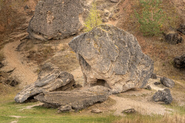 Scenic view of Šeimyniškiai outcrop with rocky formations in Lithuania. Natural sandstone cliffs surrounded by forest, showing geological layers and unique rock textures. A picturesque landscape highl
