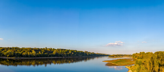 High angle panoramic view of a confluence of Narew (left) and Vistula (right) rivers with lush green banks.