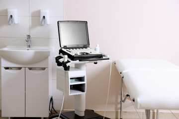 Modern ultrasound machine, sink and examination bed in clinic
