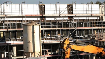 Plac budowy z widoczną koparką oraz silosem na gips © tomo81