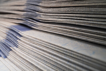 A close-up of a stack of 100 dollar banknotes.