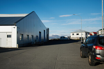 Industrial building and houses under a blue sky in rural Iceland