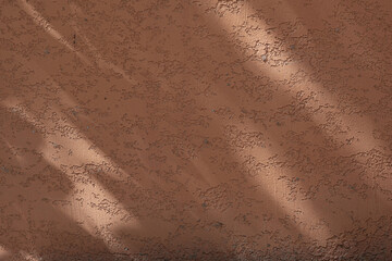 Wall with texture and shadows. Orange, brown concrete background