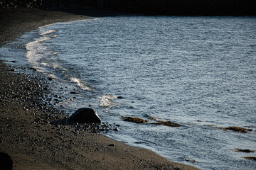 Scenic rocky coastal shore with sea waves during sunset in Iceland