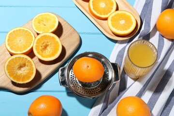 Freshly squeezed orange juice, fruits and juicer on blue wooden table, flat lay