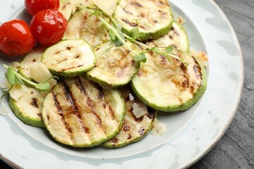 Delicious grilled courgette slices with tomatoes and microgreens on table, closeup