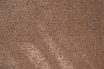 Wall with texture and shadows. Orange, brown concrete background