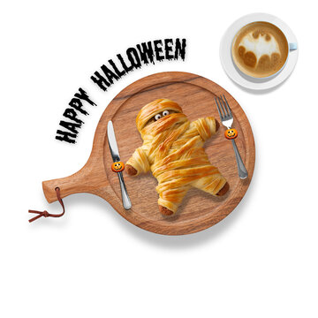 Illustration of a wooden tray with mummy-shaped bread, cutlery, Halloween pumpkins, and a latte with bat foam art, decorated with &ldquo;Happy Halloween&rdquo; text for festive use and ads.