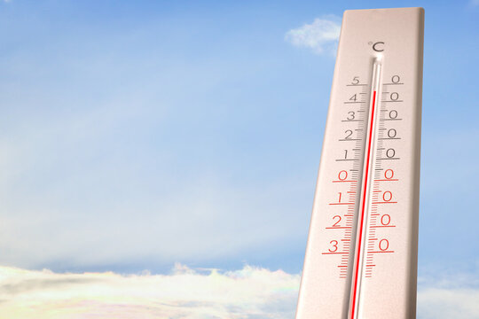 Extremely high temperature on thermometer against blue sky on sunny day. Summer weather