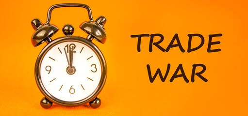 Trade war symbol. Concept word Trade war on beautiful orange paper. Beautiful black alarm clock....