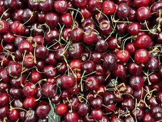 Red ripe cherries, which are used in abundance to make delicious seasonal delicacies and flavors. Bright cherries are beautifully stacked on top of each other, showing off their delicious juiciness