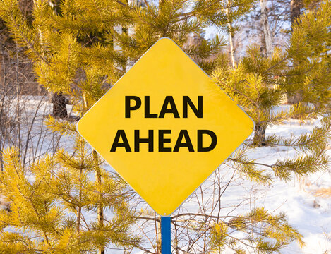 Plan ahead symbol. Concept word Plan ahead on beautiful yellow road sign. Beautiful snow winter forest background. Business plan ahead concept. Copy space.