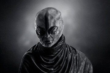 Mysterious humanoid alien at night over dark misty background