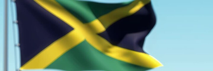 Waving Jamaican flag with bright colors on blue sky, designed as a wide website banner for global themes and online visuals