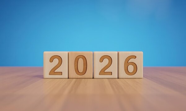 Wooden blocks displaying year 2026 on wooden table with blue background, ideal for illustrating future planning, annual events, and new year concepts