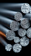 Closeup macro shot of a bundle of metallic rods with a textured, granular surface, showcasing industrial materials and manufacturing processes with a shallow depth of field