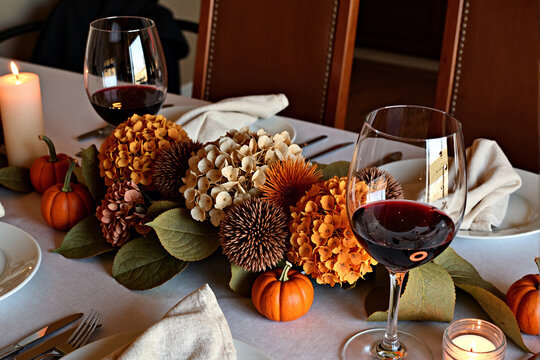 Romantic candlelit dinner for two with elegant autumn centerpiece and red wine creating an intimate and cozy atmosphere for special occasion