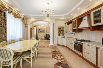 Elegant kitchen and dining area with classic style, ornate details, chandelier, and warm tones