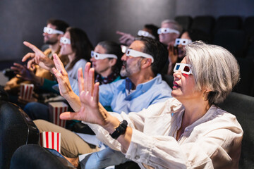 People wearing 3d glasses enjoying a 3d movie, reaching out and interacting with the immersive experience