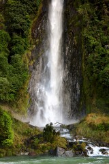 Thunder Creek Falls, South Island, New Zealand, captured on May 16, 2025, features cascading water, lush greenery, and rocky terrain in a misty natural landscape.
