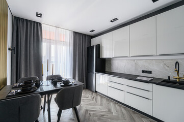 modern open-plan kitchen and dining area with light pink walls, gray cabinetry, dark wood floors,...