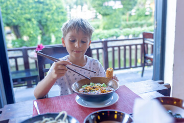 Happy european family, visting Hoi An city in Vietnam for a summer vacation, trying traditional food na watching the show in Memories Land