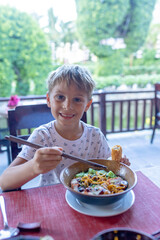 Happy european family, visting Hoi An city in Vietnam for a summer vacation, trying traditional food na watching the show in Memories Land