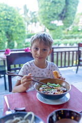 Happy european family, visting Hoi An city in Vietnam for a summer vacation, trying traditional food na watching the show in Memories Land