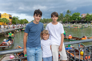 Happy european family, visting Hoi An city in Vietnam for a summer vacation, trying traditional food na watching the show in Memories Land