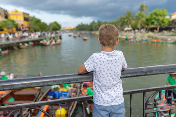 Happy european family, visting Hoi An city in Vietnam for a summer vacation, trying traditional food na watching the show in Memories Land
