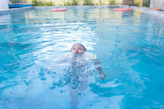 Hands of drowning person stretching out of the water in swimming pool needing help. Stress concept