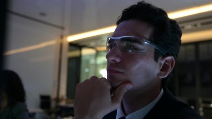 Professional cybersecurity analysts monitoring server data in dark office. Female developer pointing at code while collaborating with male colleague on urgent software project late at night. - Powered by Adobe