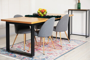 Bowl of fruits on wooden table in dining room. Interior design