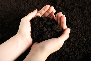 Woman with pile of fresh soil, closeup