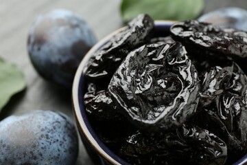 Dried prunes and fresh plums on table, closeup