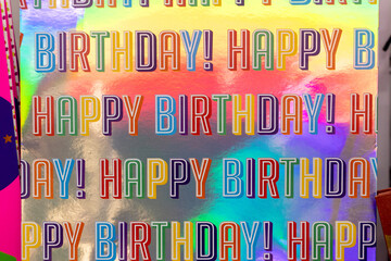 Colorful Happy Birthday inscriptions on a multi-colored surface.