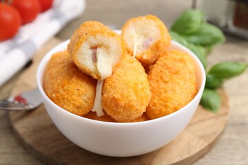 Delicious fried croquettes in bowl on table, closeup