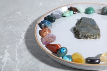 Many different healing stones on light grey table, closeup. Space for text