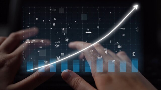 Close-up of hands typing on a keyboard, paired with a digital graph showing upward growth trends, representing the dynamic nature of the financial market and economy. Copula - Powered by Adobe