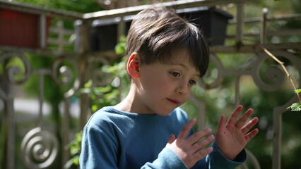 Young boy engrossed in daydreaming while enjoying a sunny day on the balcony of an apartment. the...