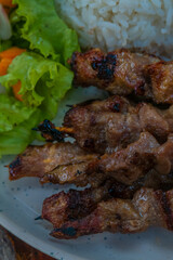 Grilled skewers with rice and fresh salad, perfect for a delicious summer meal outdoors