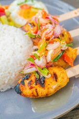 Delicious grilled chicken skewers with rice and fresh vegetables, perfect for a meal
